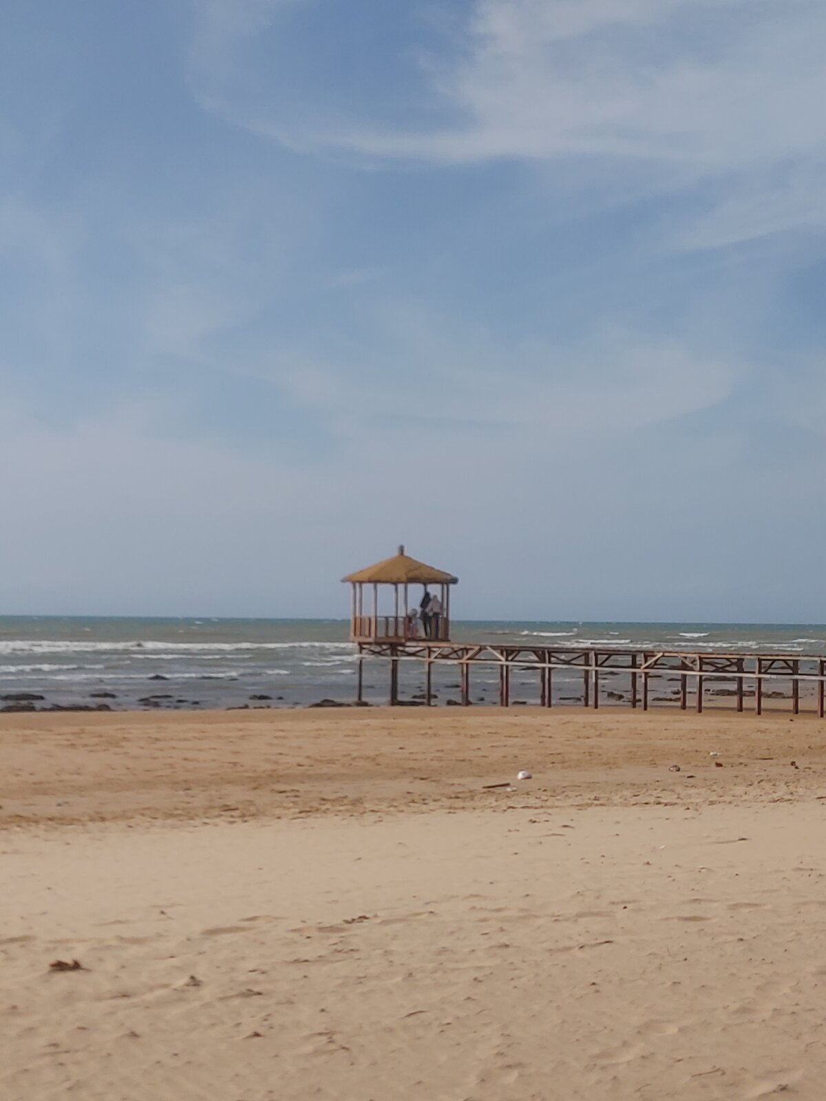 Hamparan Pasir Putih dengan Gazebo Dermaga di Kejauhan